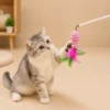 Kitten playing with the pink fish-shaped feather wand attachment