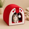 Grey tabby cat sitting inside red Cat Cave Bed looking out