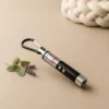 Cat laser pointer toy with carabiner clip beside lavender sprigs