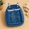 Empty blue fox-shaped cat bed showing tufted cushion and raised rim